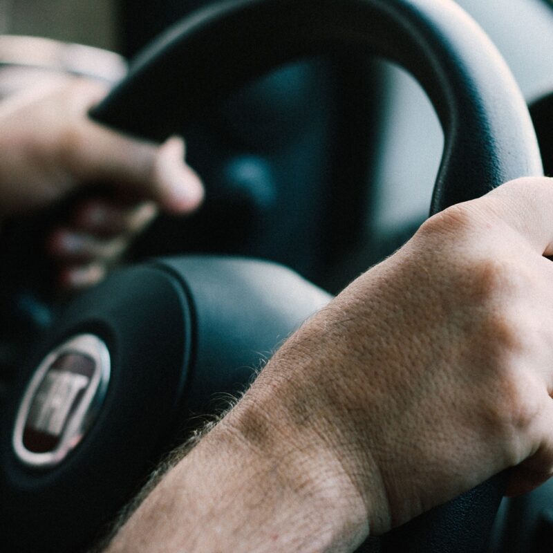 Mani di un conducente sul volante di un’automobile